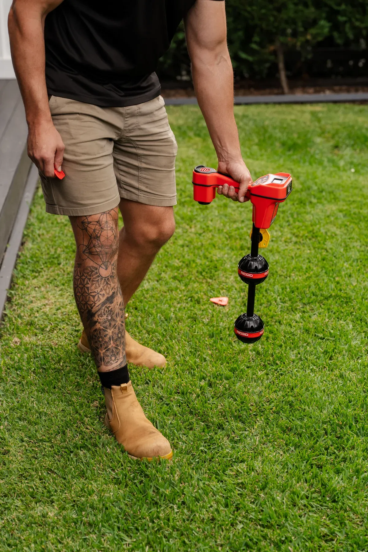 Handheld drain locator being used over a lawn
