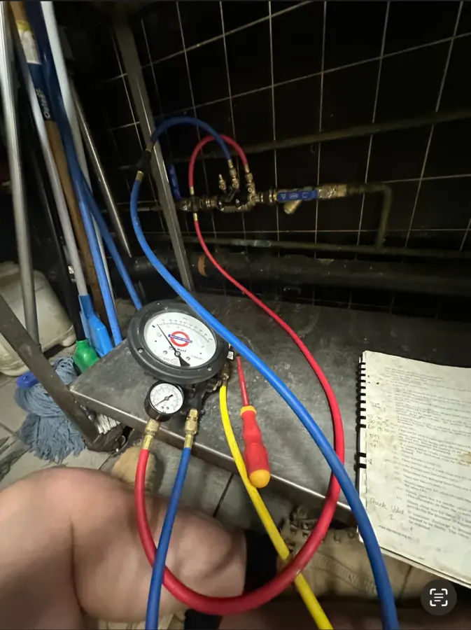 Backflow testing gauge and coloured hoses connected to a backflow prevention device